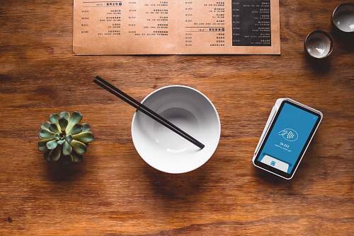 electronics black chopsticks in white ceramic bowl on table phone